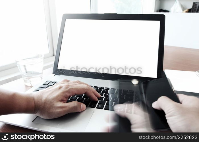 Close up of business man hand working on blank screen laptop computer on wooden desk as concept