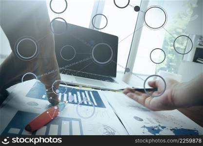 Close up of business man hand working on blank screen laptop computer on wooden desk as concept with social media diagram