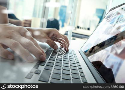 Close up of business man hand working on laptop computer with business strategy diagram on wooden desk as concept