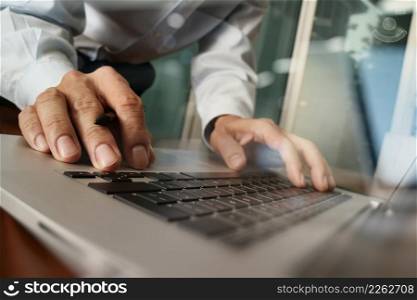 Close up of business man hand working on laptop computer with digital business strategy diagram on wooden desk as concept