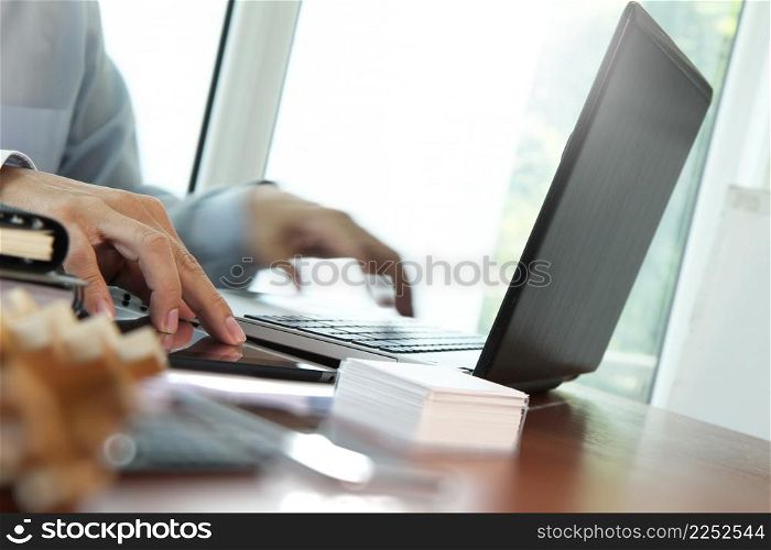 Close up of business man hand working on laptop computer with social media diagram on wooden desk as concept