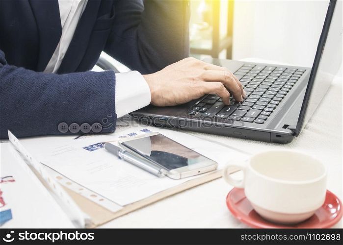 Close up of business man hands typing on laptop computer