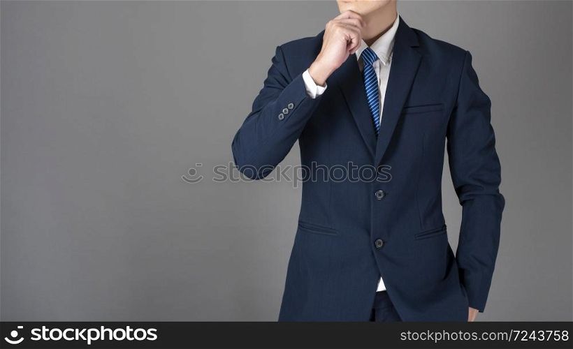 Close up of business man in blue suit is thinking on gray background