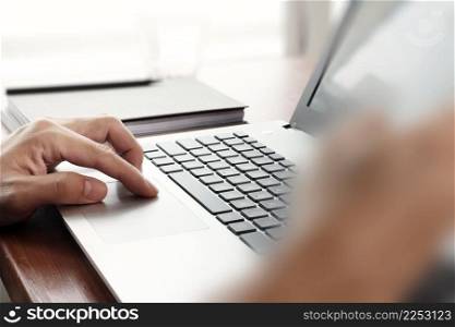 Close up of business man working on laptop computer on wooden desk as concept