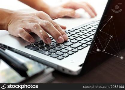 Close up of business man working on laptop computer with social network diagram on wooden desk as concept