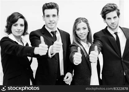 Close-up of business team holding their thumbs up
