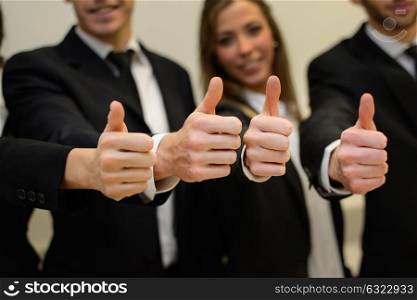 Close-up of business team holding their thumbs up