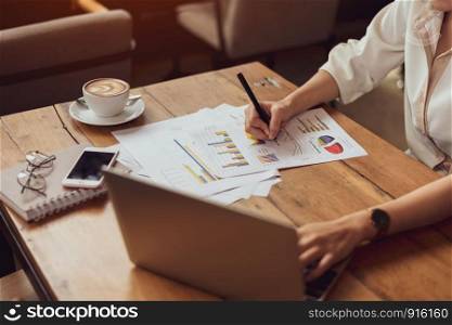 Close up of business woman working with documents and laptop in office. Business and Lifestyles concept. Entrepreneur and Freelance theme.