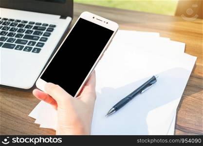 Close-up of Business woman working with smartphone,laptop and document in coffee shop like the background.