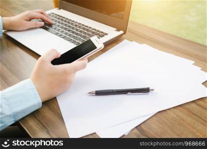 Close-up of Business woman working with smartphone,laptop and document in coffee shop like the background.