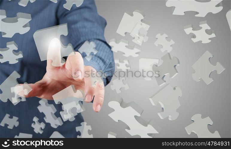 Close up of businessman&amp;#39;s hand touching abstract puzzle piece