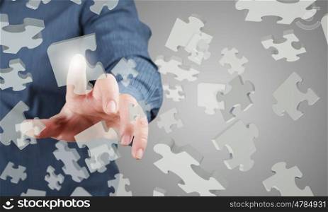 Close up of businessman&amp;#39;s hand touching abstract puzzle piece