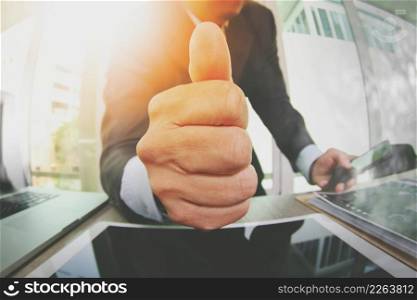 close up of businessman giving thumbs up in his office as concept