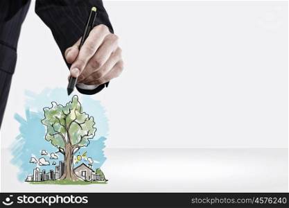 Close up of businessman hand drawing sketches of buildings. Draw your dream