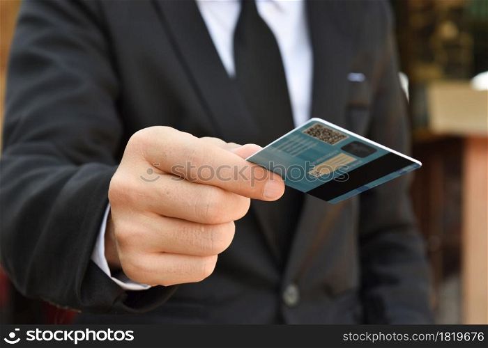 Close-up of businessman hand hold credit card. Selective focus at hands.
