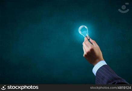 Close up of businessman hand holding glass light bulb. Bulb in hand