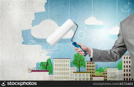 Close up of businessman hand painting wall with roller. Hand with roller