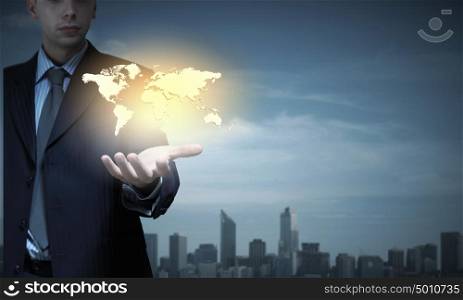 Close up of businessman hand presenting world map. Rule the world