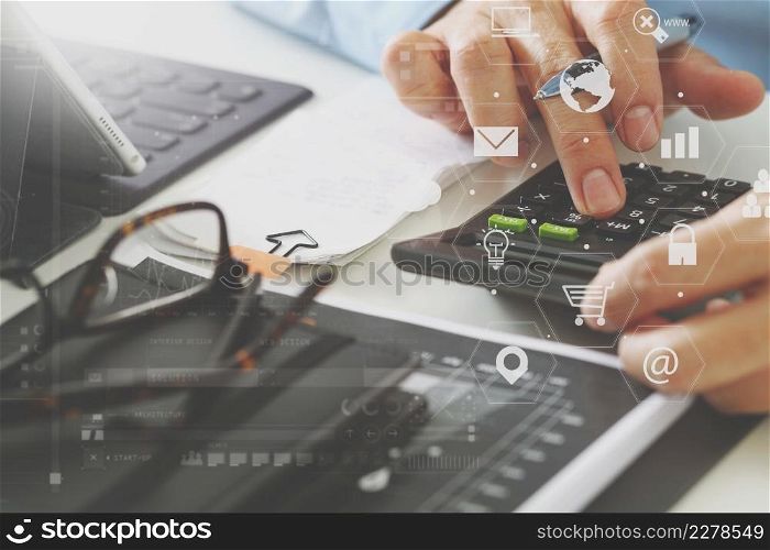 close up of businessman hand working with finances about cost and calculator and latop with mobile phone on withe desk in modern office with VR icon diagram