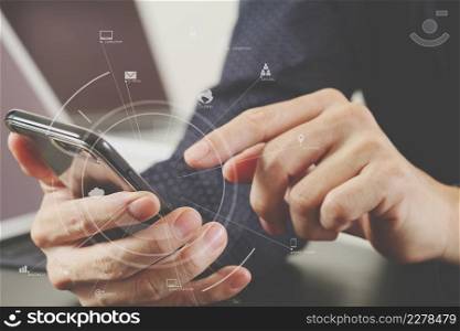 close up of businessman hand working with mobile phone and laptop and digital tablet computer in modern office with virtual icon diagram