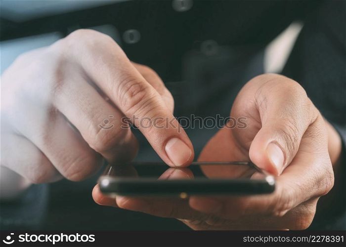 close up of businessman hand working with smart phone in modern office with glass reflected view