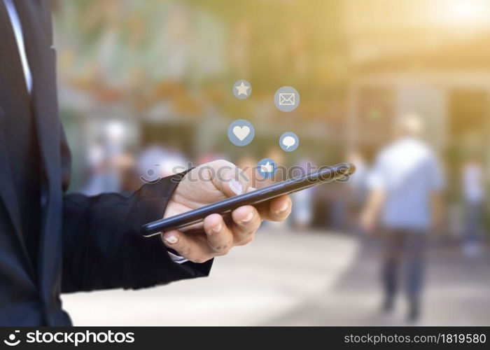 Close-up of businessman hands using mobile smartphone with social media icon. Idea for business, online marketing and technology.