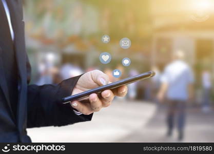 Close-up of businessman hands using mobile smartphone with social media icon. Idea for business, online marketing and technology.