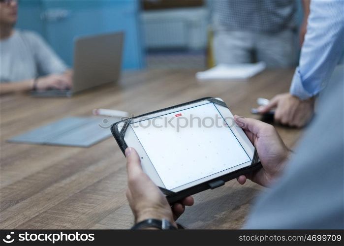 close up of businessman hands using tablet computer on start up business meeting