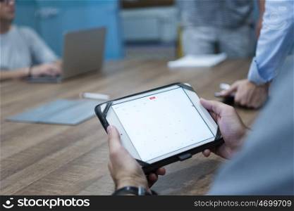 close up of businessman hands using tablet computer on start up business meeting