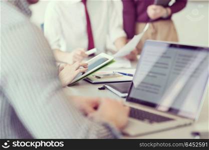 close up of businessman hands using tablet people group in office meeting room blurred in backgronud