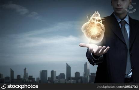 Close up of businessman holding digital heart in palm. Heart in hand