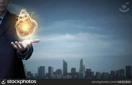 Close up of businessman holding digital heart in palm. Heart working mechanisms