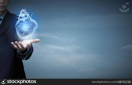 Close up of businessman holding digital heart in palm. Heart working mechanisms