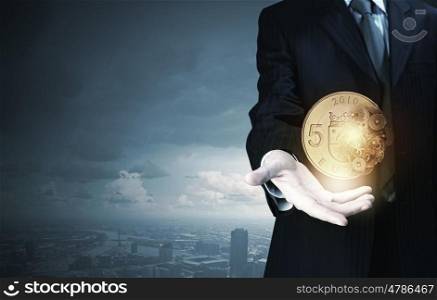 Close up of businessman holding euro coin in hand. Euro currency