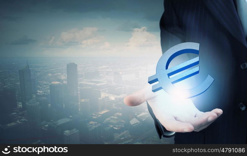 Close up of businessman holding euro symbol in his palm. Euro currency