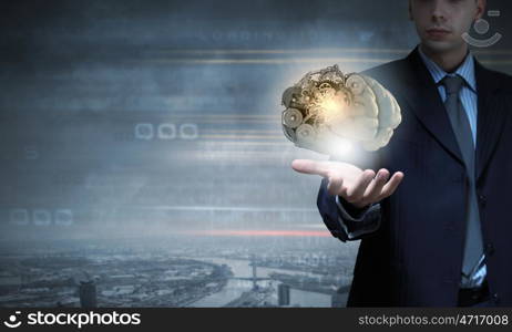 Close up of businessman holding human brain in hand. Brainstorming mechanism