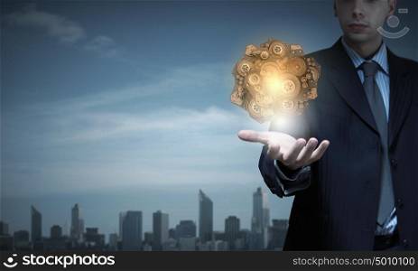Close up of businessman holding human brain in hand. Brainstorming mechanism