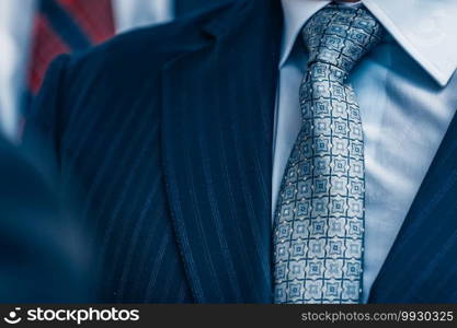 Close up of businessman in group wearing suit and tie. 