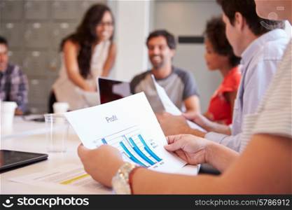 Close Up Of Businessman Looking At Profit Graph In Meeting
