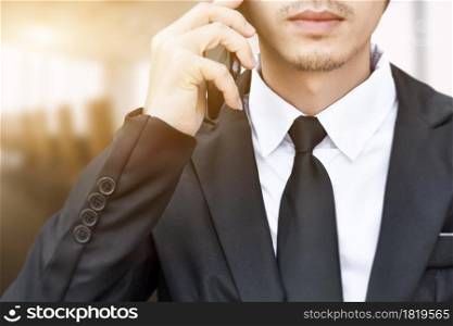 Close up of businessman making a phone call with smartphone.