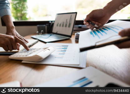 Close up of businessman pointing on chart of financial document and businesswoman using calculator.