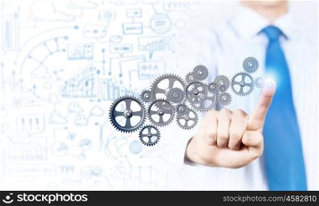 Close up of businessman pushing gear icon on media screen. Businessman activating gears mechanism