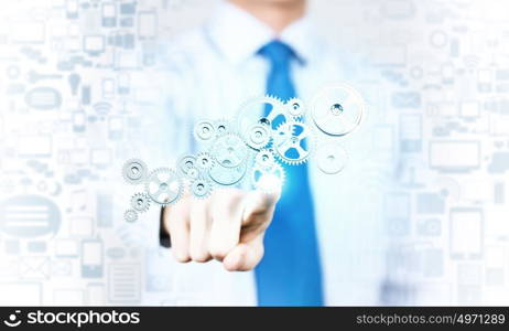 Close up of businessman pushing gear icon on media screen. Businessman activating gears mechanism