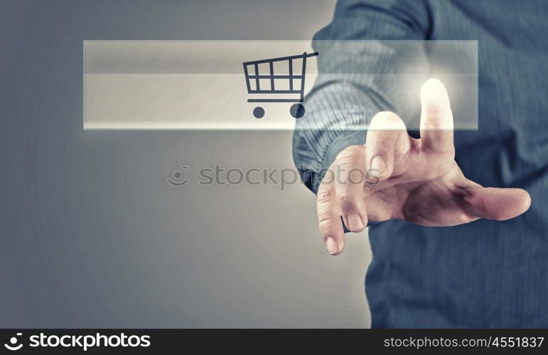 Close up of businessman pushing shopping cart icon. Shopping online