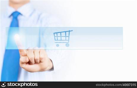 Close up of businessman pushing shopping cart icon. Shopping online