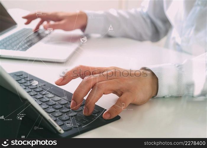 close up of businessman typing keyboard with laptop computer and digital tablet on white desk in modern office with VR icon diagram