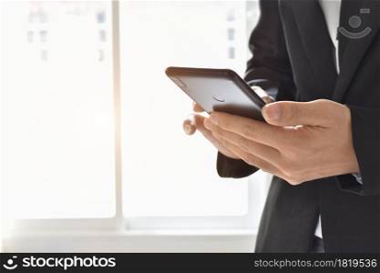 Close up of businessman using a cell phone. Young business executive with mobile phone .
