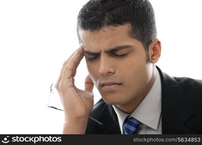 Close-up of businessman with headache over white background