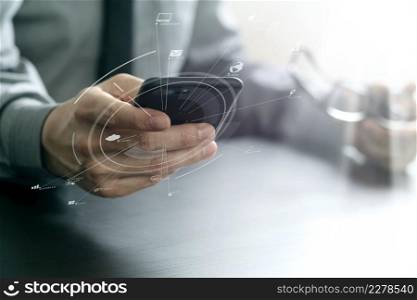 close up of businessman working with mobile phone and eyeglass on wooden desk in modern office with virtual reality icon diagram
