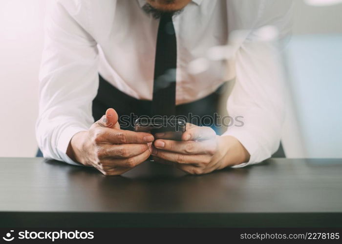 close up of businessman working with mobile phone on wooden desk in modern office with virtual icon diagram with glass reflected view